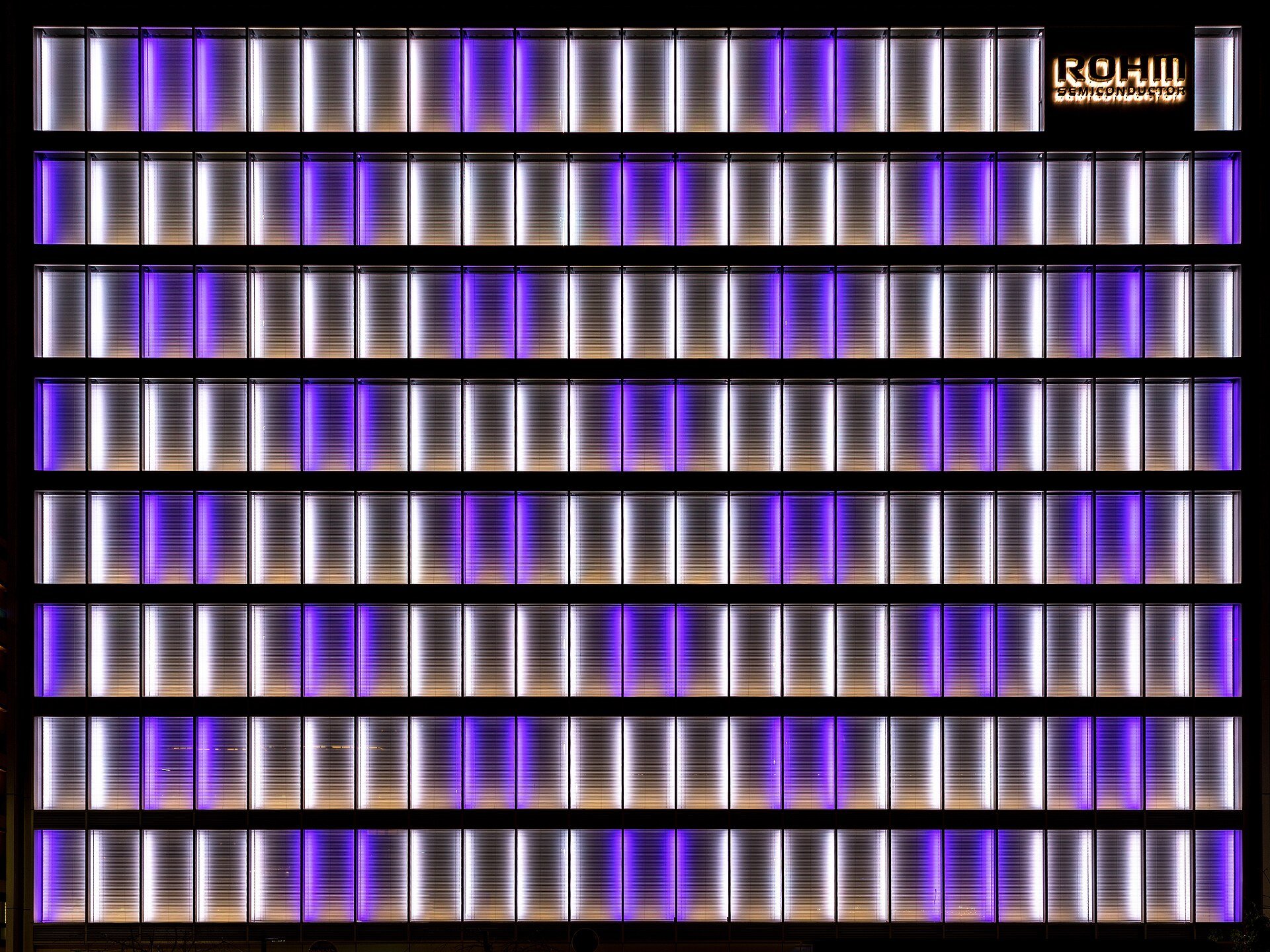 Parede com painéis verticais iluminados em roxo e branco
